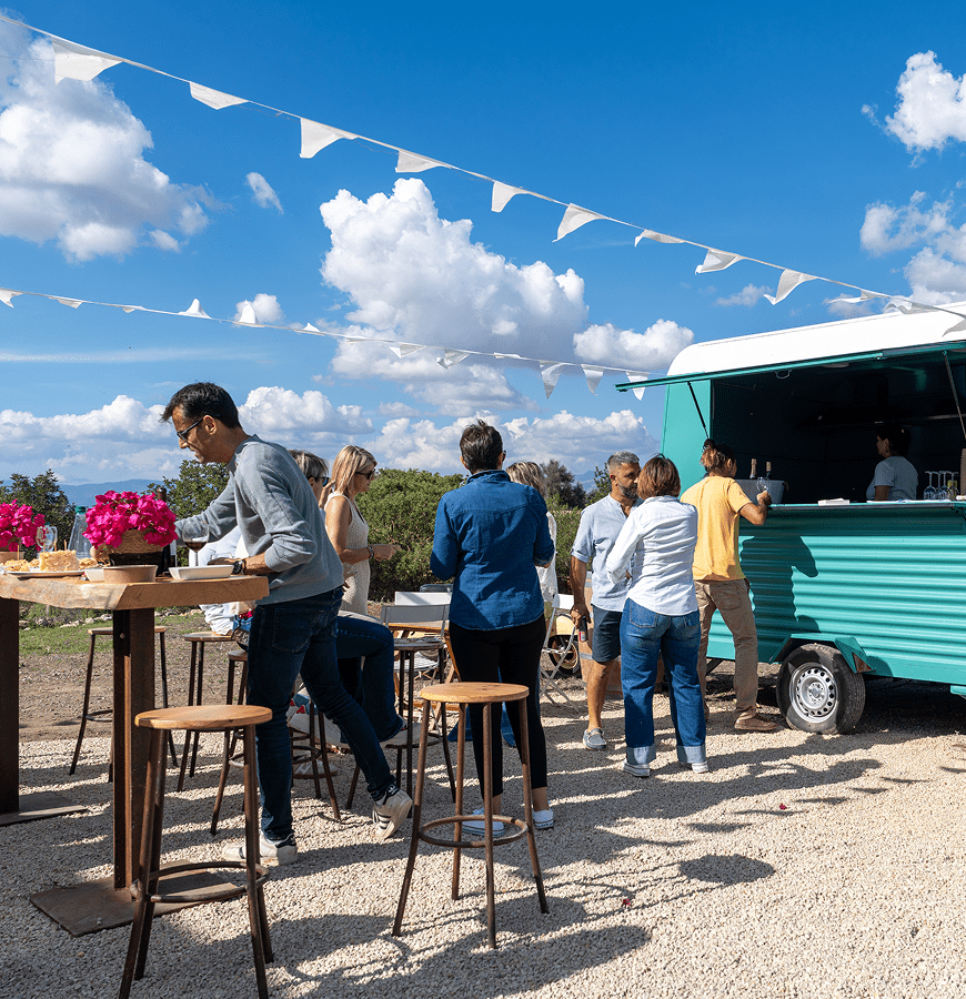 People gathered at outdoor food truck event.