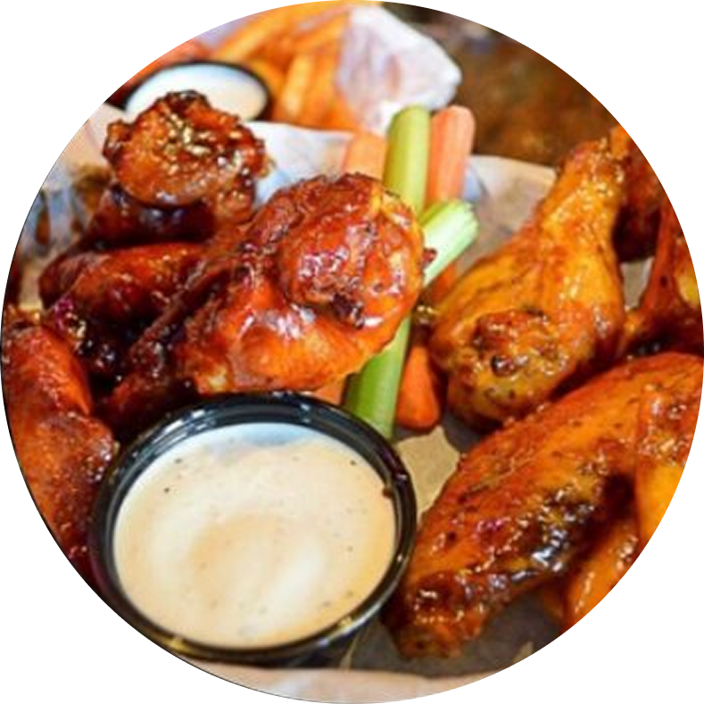 Chicken wings with dipping sauce and vegetables.