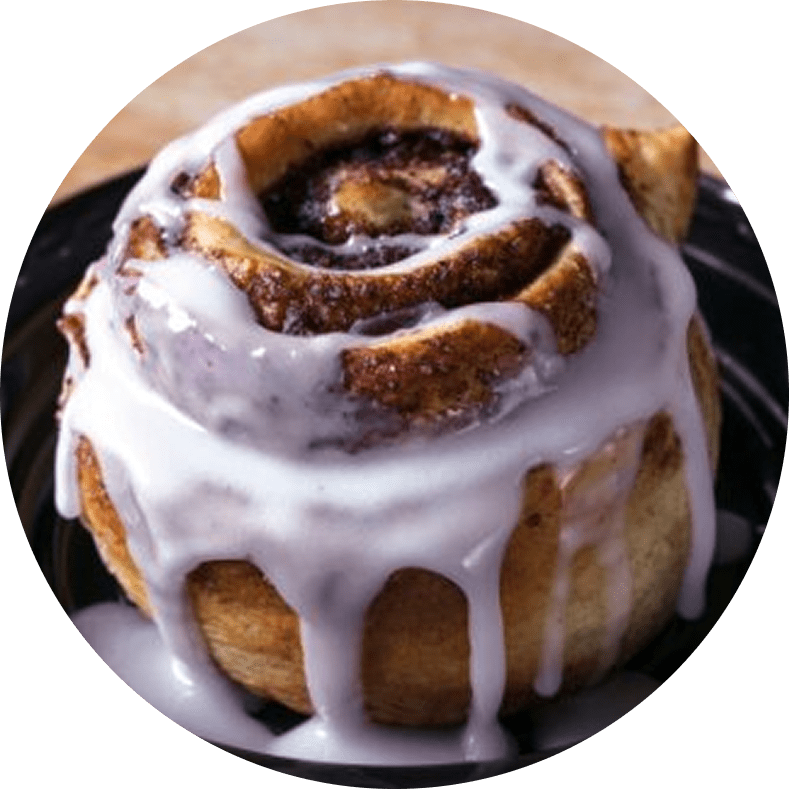 Cinnamon roll with icing on a plate.