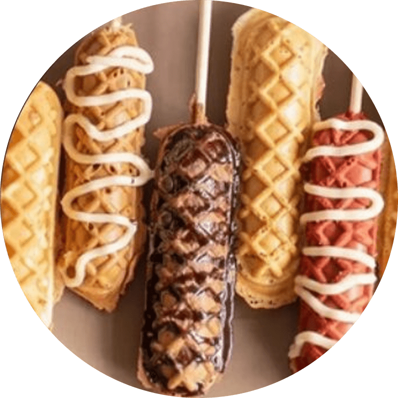 Waffle corn dogs with various toppings.