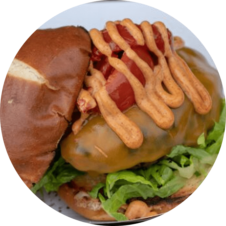 Cheeseburger with lettuce, sauce, and tomatoes.