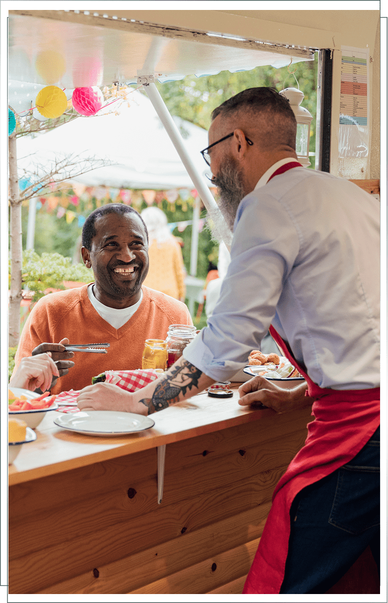 Man smiling at server in food truck.