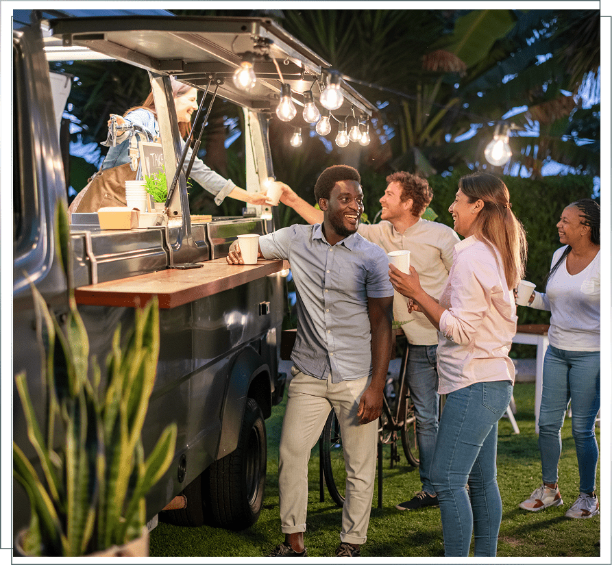People socializing at a food truck outdoors.